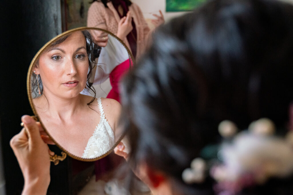 Mariée concentrée sur son maquillage, reflet dans un miroir – préparatifs élégants à Bordeaux