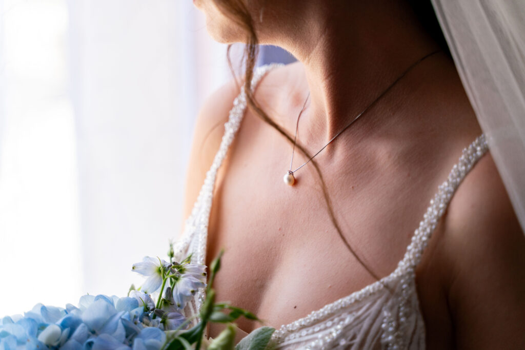 photographe mariage Marmande – détail robe de mariée et bouquet bleu en lumière naturelle
