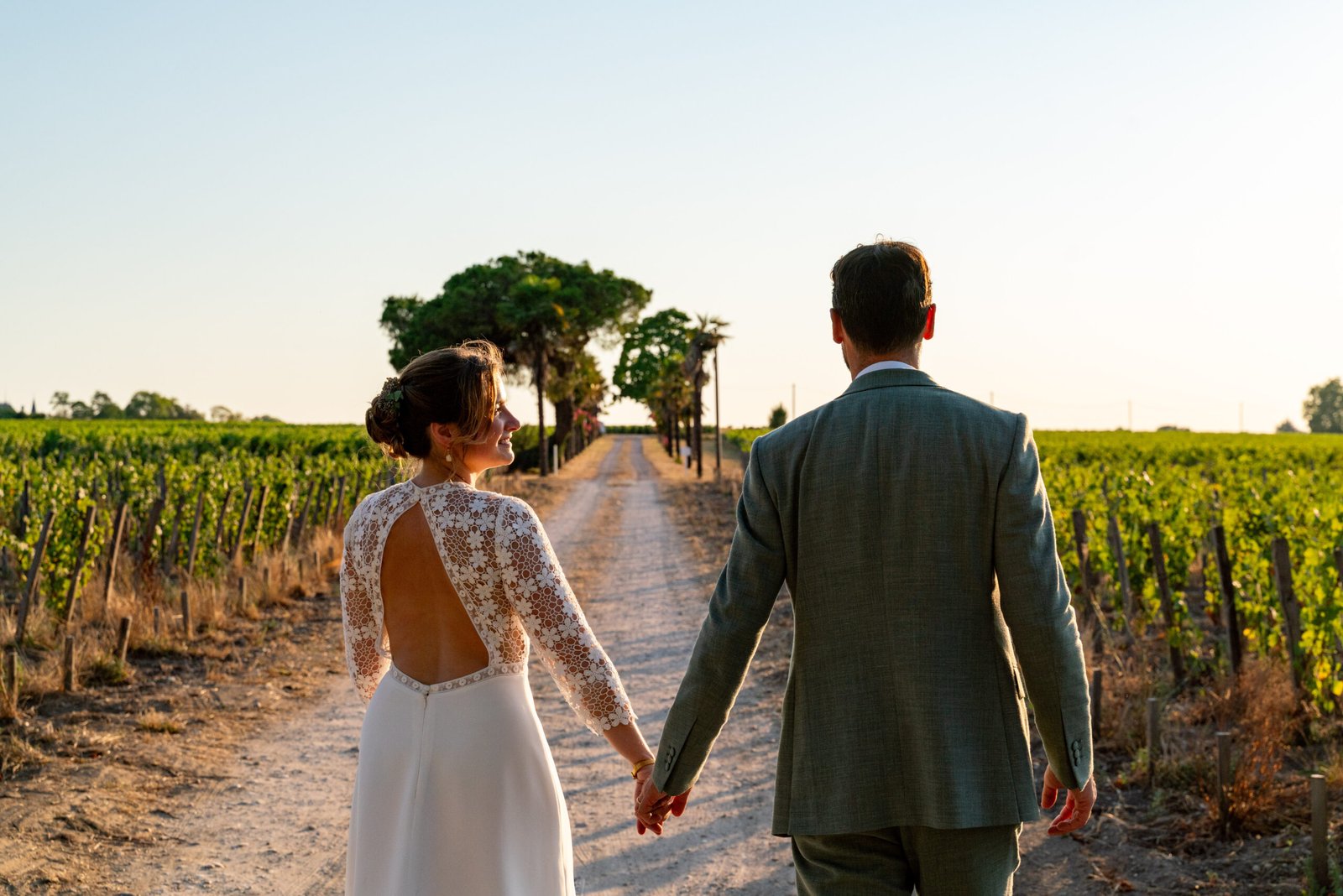 Mariés se tenant la main dans les vignes, mariage à Bordeaux