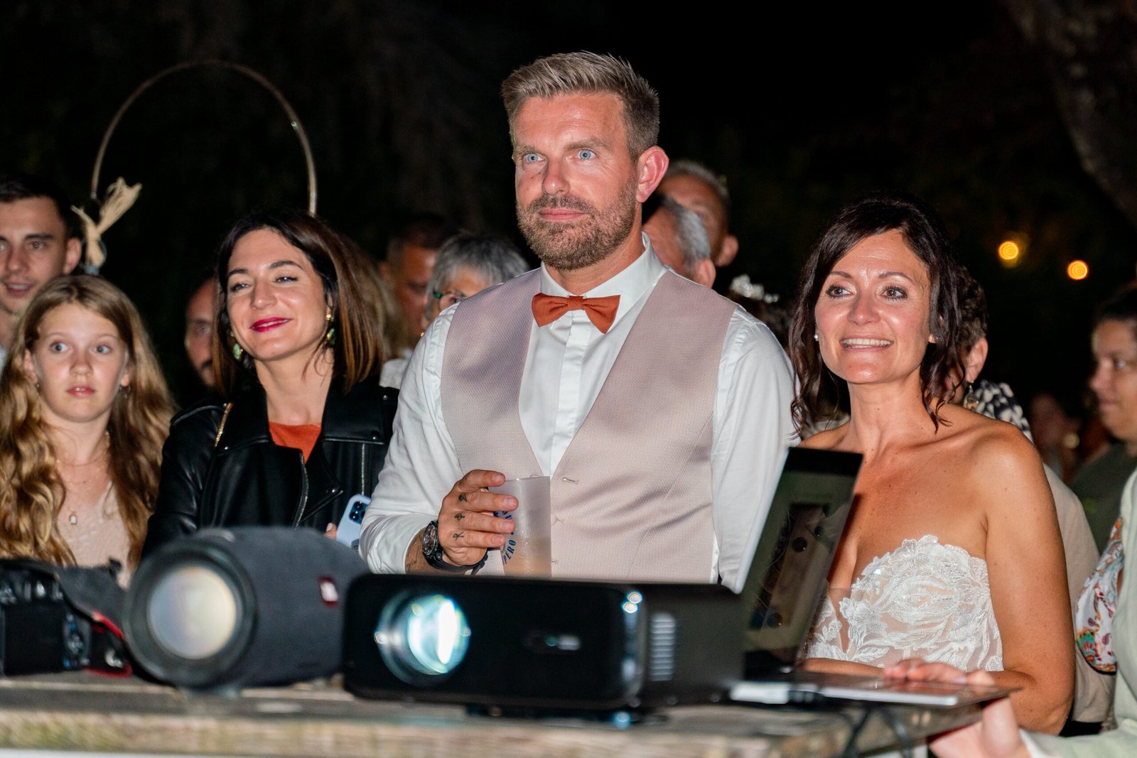 Mariés et invités regardant une projection de photos en soirée, mariage à Périgueux