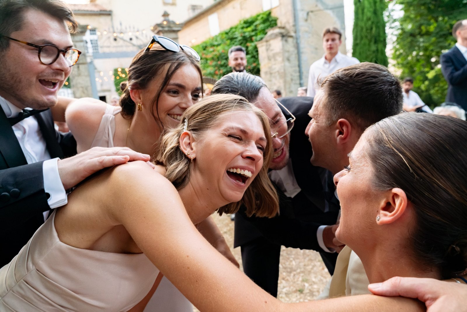 Mariée entourée de proches riant ensemble, mariage à Saint-Emilion